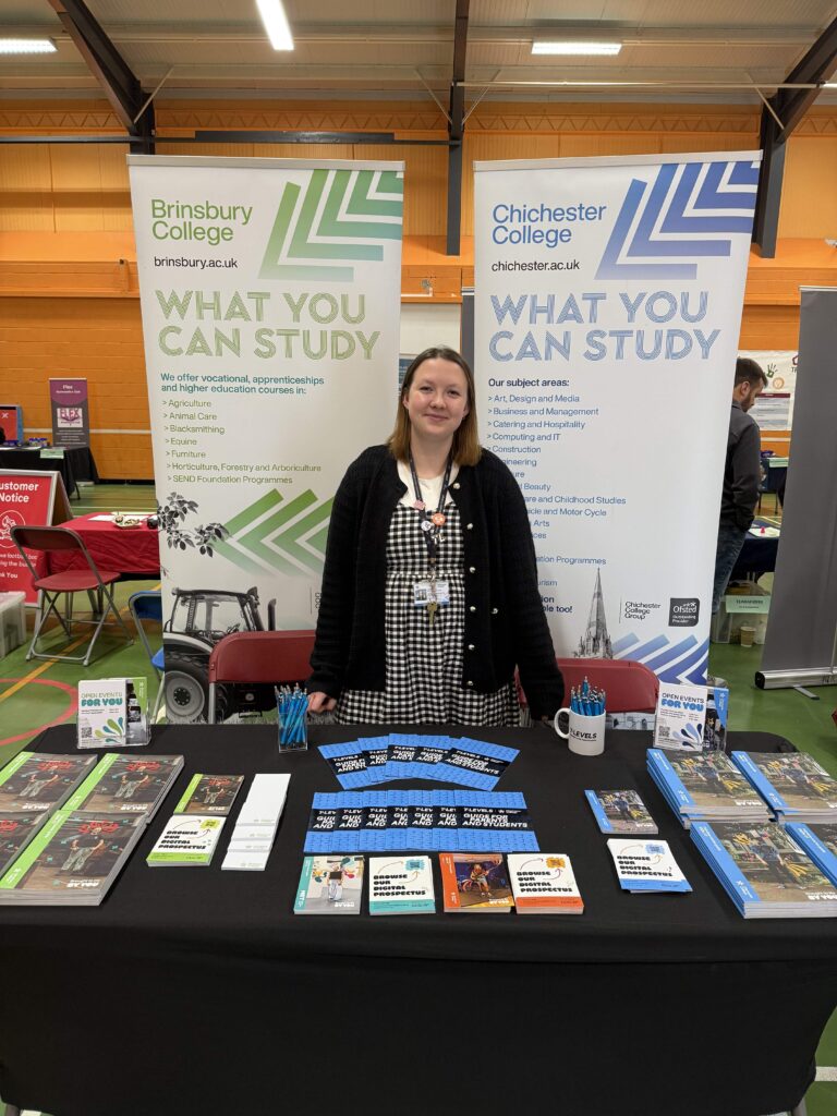 Sophie Holbourne standing at a Chichester College information desk