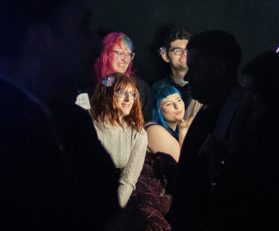 A group of students being lit by spotlight in a darkened studio
