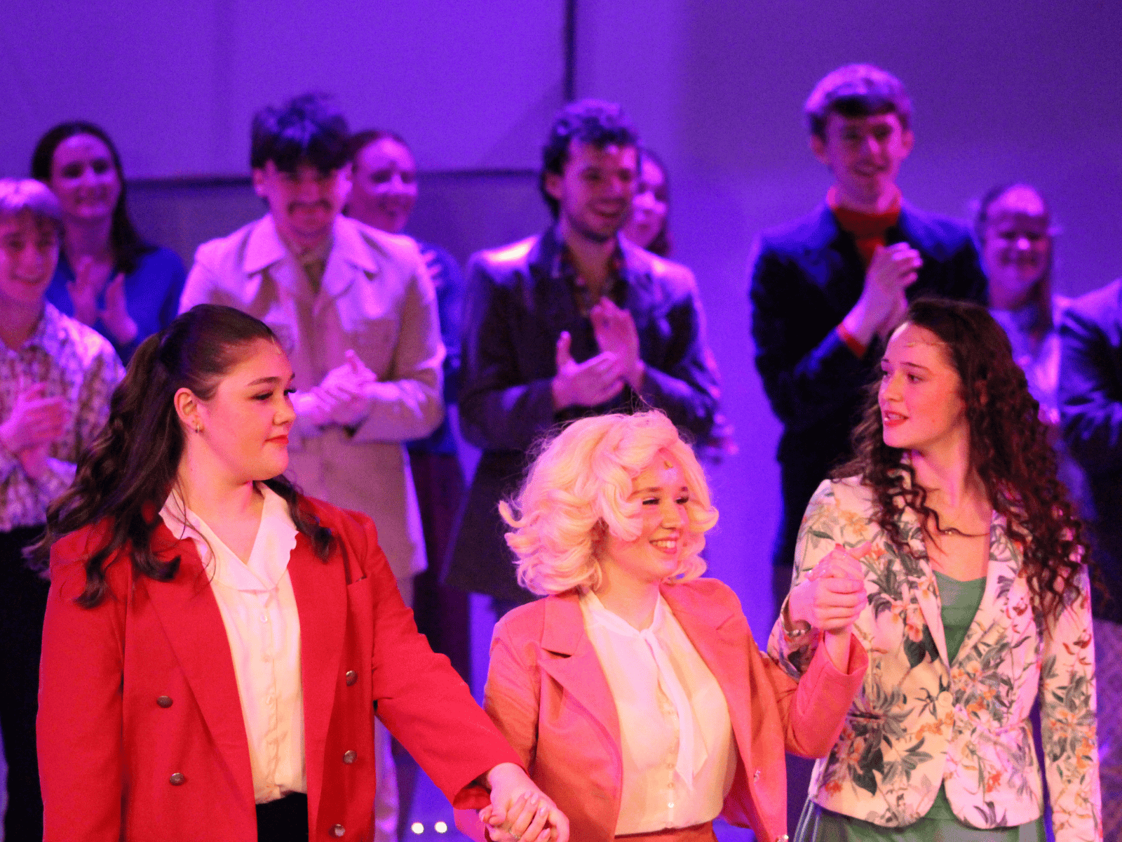 Our students raising hands as they take the audience's applause at the end of the show