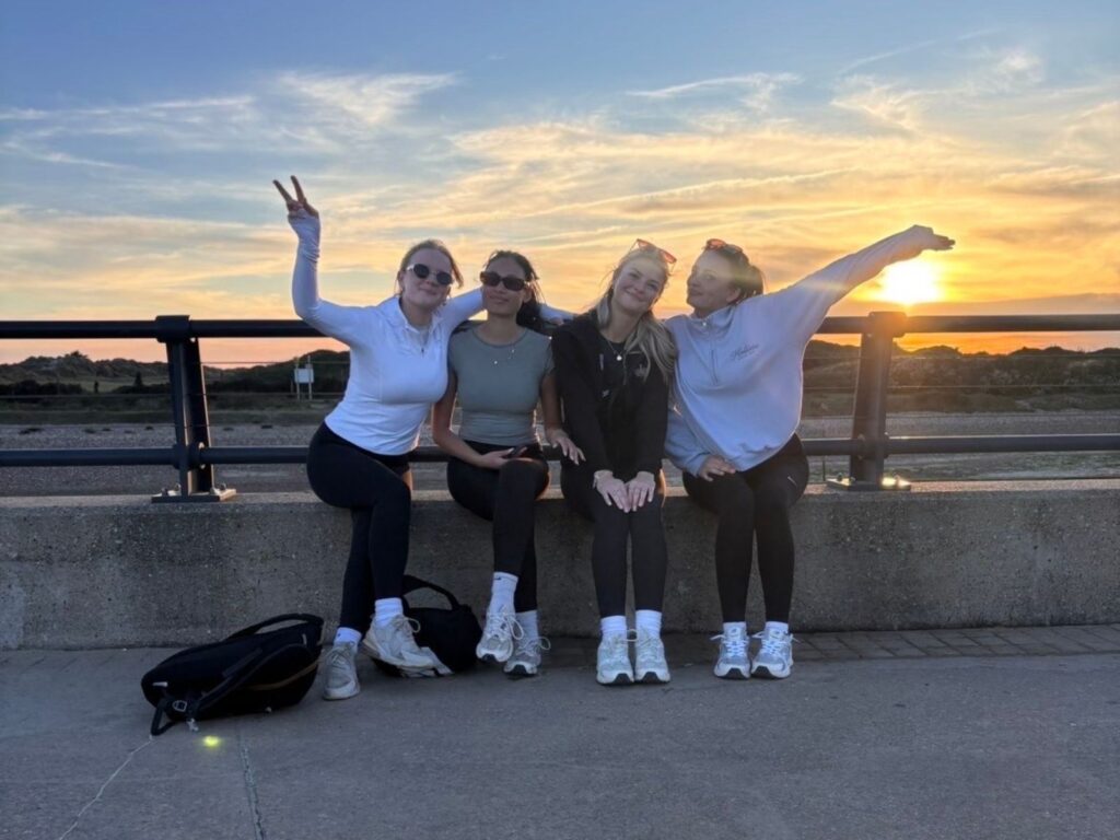 The Four students sat on a wall during their marathon charity walk